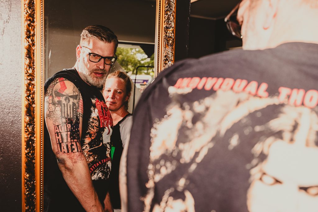 Kunde betrachtet neues Tattoo im Spiegel